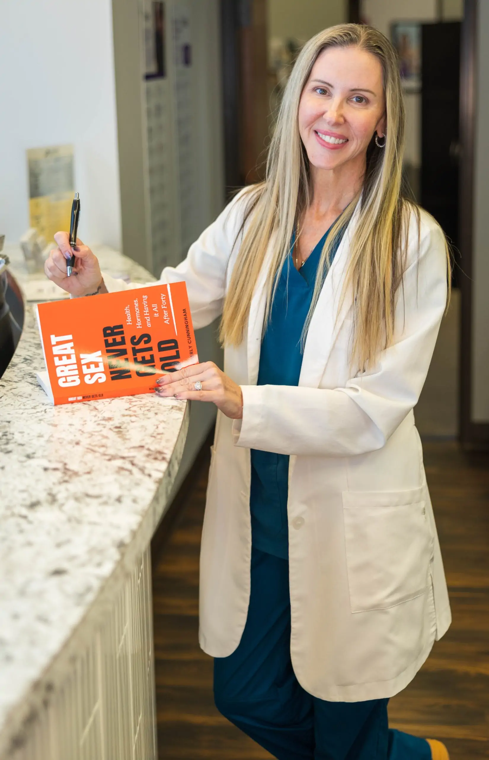 Kimberly happily smiling holding her book looking at the camera